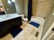 Bathroom with a dark vanity, shower/tub with neutral tiling, and stylish blue bath mats at 7825 Crownpoint Dr, Alpharetta, GA 30005