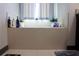 Bathroom tub with tile surround and plenty of space for soaps and bath supplies at 7825 Crownpoint Dr, Alpharetta, GA 30005