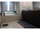 Bathroom featuring a soaking tub, dark cabinets, and granite countertop space at 7825 Crownpoint Dr, Alpharetta, GA 30005