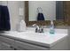 Bathroom sink with a white countertop, chrome faucet, and a decorative framed mirror at 7825 Crownpoint Dr, Alpharetta, GA 30005