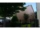 View of the home's tan siding, black fence, green shrubbery, and manicured lawn at 7825 Crownpoint Dr, Alpharetta, GA 30005