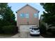 Front exterior view of two story home with garage, driveway, and fenced yard with landscaping at 7825 Crownpoint Dr, Alpharetta, GA 30005