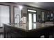 Kitchen view with a granite countertop island with dark cabinets and decorative pendant lighting at 7825 Crownpoint Dr, Alpharetta, GA 30005
