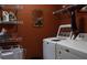 Functional laundry room with washer, dryer, shelving, and a warm, inviting wall color at 7825 Crownpoint Dr, Alpharetta, GA 30005