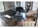 Inviting living room with a grand piano, plush seating, and natural light streaming through the window at 7825 Crownpoint Dr, Alpharetta, GA 30005