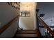 Staircase with hardwood railing leading up to a decorative light fixture and artwork at 7825 Crownpoint Dr, Alpharetta, GA 30005