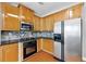 This kitchen has stainless steel appliances, a stone backsplash and hardwood floors at 1999 Barrett Knoll Nw Cir, Kennesaw, GA 30152
