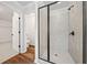 Modern walk-in shower with glass enclosure and ceramic tile walls, situated near an open doorway at 3865 Rifflepool Ct, Douglasville, GA 30135