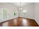 Bright dining room featuring a door to the deck, wood floors, and modern light fixture at 3865 Rifflepool Ct, Douglasville, GA 30135