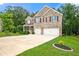 Beautiful two-story brick home with a manicured lawn, complemented by trees and a spacious two-car garage at 3865 Rifflepool Ct, Douglasville, GA 30135
