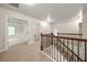 Hallway boasts carpet, wood railings, and an entryway into a bedroom and bathroom at 3865 Rifflepool Ct, Douglasville, GA 30135