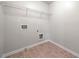 Bright laundry room features tile flooring, convenient shelving, and washer/dryer hookups at 3865 Rifflepool Ct, Douglasville, GA 30135