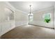 Bright, carpeted living room featuring an archway and large windows allowing natural light to illuminate the space at 3865 Rifflepool Ct, Douglasville, GA 30135