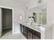 Bright bathroom features a double sink vanity, white marble countertops, and walk-in closet access at 4808 Albany Way, Atlanta, GA 30331