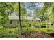 Charming back exterior view of home featuring lush greenery and a spacious wooden deck at 537 Raven Springs Trl, Stone Mountain, GA 30087