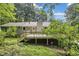 Secluded back exterior showcasing a spacious wooden deck with stairs and lush trees at 537 Raven Springs Trl, Stone Mountain, GA 30087