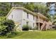 Two-story home with a front porch and stairs surrounded by greenery and trees at 537 Raven Springs Trl, Stone Mountain, GA 30087