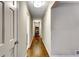 Well-lit hallway features hardwood floors, neutral paint, and access to various rooms in the home at 537 Raven Springs Trl, Stone Mountain, GA 30087