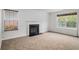 Carpeted living room featuring a fireplace and two windows for natural light at 926 Hawthorn Ln, Grayson, GA 30017