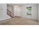Carpeted living room with stairs, double door closet and large window at 926 Hawthorn Ln, Grayson, GA 30017