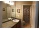 Well-lit bathroom featuring framed mirrors, double doors, and tiled floors at 3299 Arbor Oaks Dr, Snellville, GA 30039