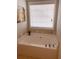 Relaxing bathroom featuring a large soaking tub with tile surround and decorative wall art at 3299 Arbor Oaks Dr, Snellville, GA 30039