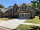 Beautiful two-story home featuring brick accents, attached garage, and a well-maintained front lawn at 3299 Arbor Oaks Dr, Snellville, GA 30039