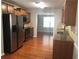 Modern kitchen with stainless steel appliances, granite countertops, and rich hardwood flooring at 3299 Arbor Oaks Dr, Snellville, GA 30039