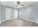 Bedroom featuring gray walls, gray wood flooring, a ceiling fan, and a window at 3918 S Creek Ct, Stone Mountain, GA 30083