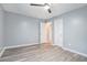 This bedroom features gray walls, gray wood flooring, a ceiling fan, and white doors at 3918 S Creek Ct, Stone Mountain, GA 30083