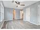 This bedroom features gray walls, gray wood flooring, a ceiling fan, and white doors at 3918 S Creek Ct, Stone Mountain, GA 30083