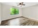 Comfortable bedroom featuring laminate flooring, ceiling fan, and a window overlooking the backyard at 558 Newlin Ct, Lawrenceville, GA 30046