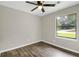 A cozy bedroom with a ceiling fan, a window, and beautiful hardwood floors at 558 Newlin Ct, Lawrenceville, GA 30046