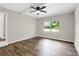 This bedroom is bright and airy with laminate flooring, a ceiling fan, and a window overlooking the yard at 558 Newlin Ct, Lawrenceville, GA 30046