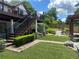 This backyard offers a deck with stairs, a brick walkway, synthetic grass, and attractive landscaping at 1570 Cedars Rd, Lawrenceville, GA 30045
