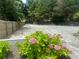 Open gravel lot surrounded by a wooden fence and manicured landscaping at 1570 Cedars Rd, Lawrenceville, GA 30045