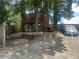 This backyard features a wooden playhouse, a leveled landscape, privacy fence, and shade trees at 1570 Cedars Rd, Lawrenceville, GA 30045