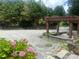 This beautiful backyard offers a pergola, trees, rocks, and hydrangeas for a relaxing outdoor space at 1570 Cedars Rd, Lawrenceville, GA 30045