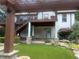The covered deck with stone pillars overlooks the landscaped backyard and patio at 1570 Cedars Rd, Lawrenceville, GA 30045