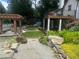 Well-manicured lawn and landscaping surround the gravel yard and home with a covered deck at 1570 Cedars Rd, Lawrenceville, GA 30045