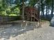 This backyard features a wooden playhouse, a leveled landscape, privacy fence, and shade trees at 1570 Cedars Rd, Lawrenceville, GA 30045