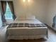 Comfortable bedroom featuring neutral-colored walls, window, and a large queen bed with patterned bedding at 1570 Cedars Rd, Lawrenceville, GA 30045