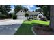 Charming single-story home with a well-manicured lawn, long driveway and a two-car garage at 1570 Cedars Rd, Lawrenceville, GA 30045