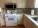 Kitchen area with light marble counters and white appliances at 1570 Cedars Rd, Lawrenceville, GA 30045