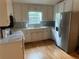 Bright kitchen featuring stainless steel appliances, white cabinets, and hardwood floors at 1570 Cedars Rd, Lawrenceville, GA 30045