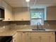 Granite countertops with decorative tile backsplash, stainless faucet, sink, and white cabinets are featured in this kitchen at 1570 Cedars Rd, Lawrenceville, GA 30045