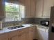 Sunlit kitchen boasts marble countertops, a stainless steel sink, and a large window overlooking the yard at 1570 Cedars Rd, Lawrenceville, GA 30045