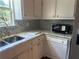 Kitchen features a marble countertop, diamond pattern backsplash, and white cabinets at 1570 Cedars Rd, Lawrenceville, GA 30045