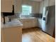 Bright kitchen featuring stainless steel appliances, white cabinets, and hardwood floors at 1570 Cedars Rd, Lawrenceville, GA 30045