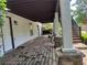 This home features a covered patio with stone columns, access to the backyard and stairs to an upper deck at 1570 Cedars Rd, Lawrenceville, GA 30045